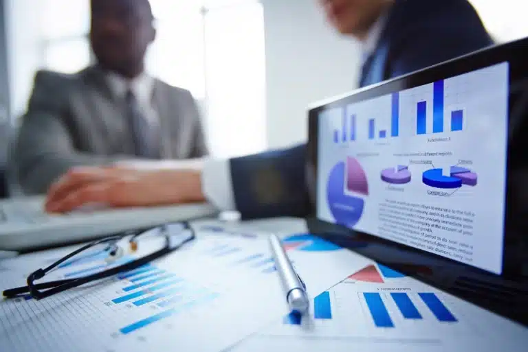 Business meeting with charts and graphs on screen and paper