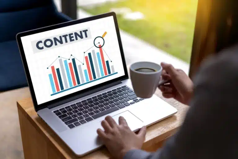 Person viewing content analytics on laptop with coffee