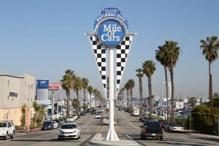 National City Mile of Cars sign on busy street with dealerships and palm trees, representing local businesses supported by Tower25 digital marketing agency near National City.