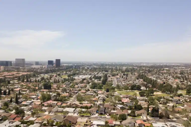Scenic view of La Mesa, California, featuring tree-lined streets, hillside homes, and a vibrant downtown area under sunny skies.