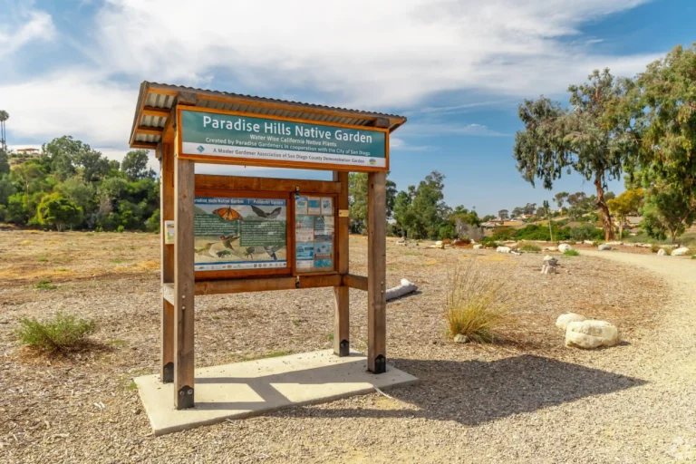 Paradise Hills neighborhood entrance sign with community information board and landscaped surroundings.